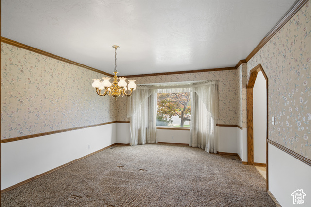 1373 Pheasant Ridge Circle Bountiful, UT 84010 - Photo 16 of 50 Room featuring a bay window, patterned wallpaper, a brass chandelier, and an arched doorway
