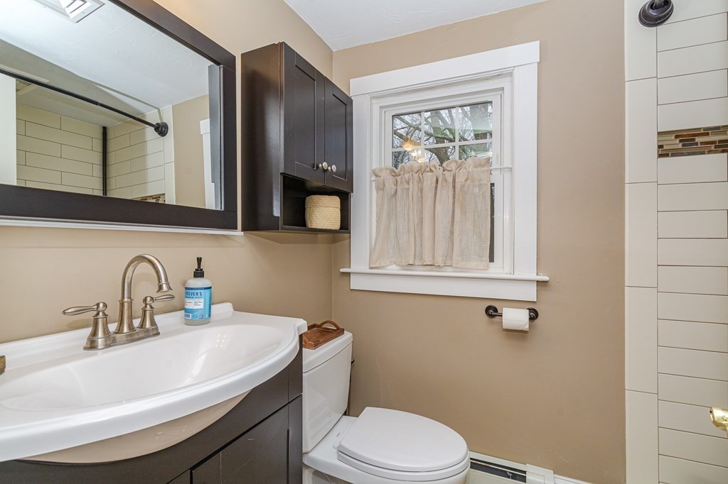 39 Chittick Road Boston, MA 02136 - Photo 18 of 24 a bathroom with a sink a mirror a toilet and a window