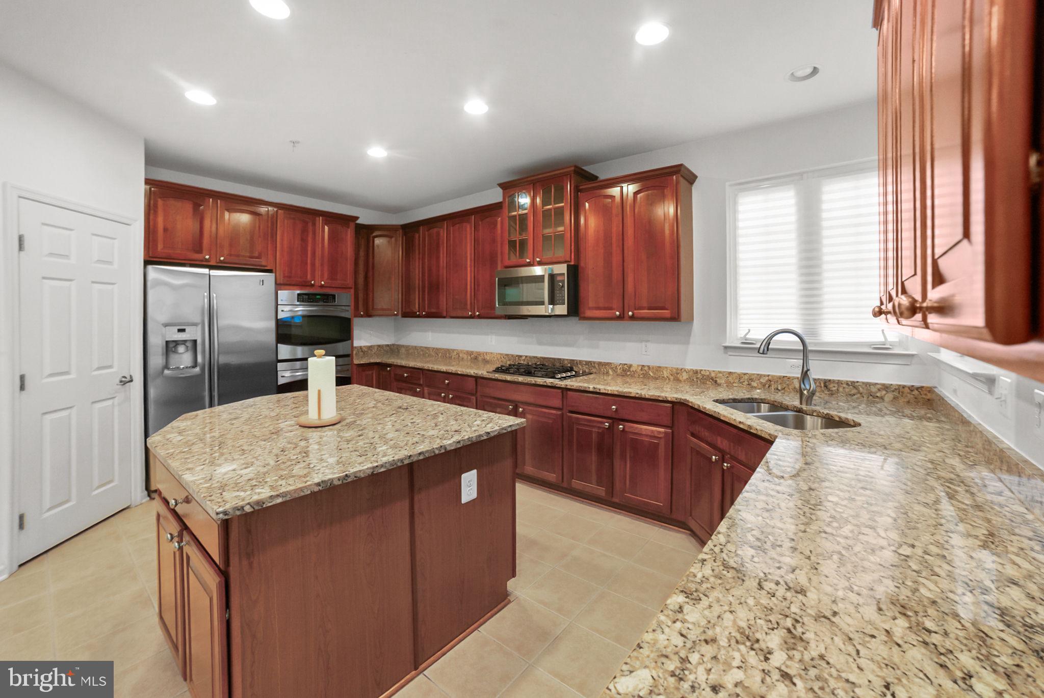 14909 Taryn Lea Court Accokeek, MD 20607 - Photo 19 of 49 a kitchen with stainless steel appliances granite countertop a sink stove and refrigerator