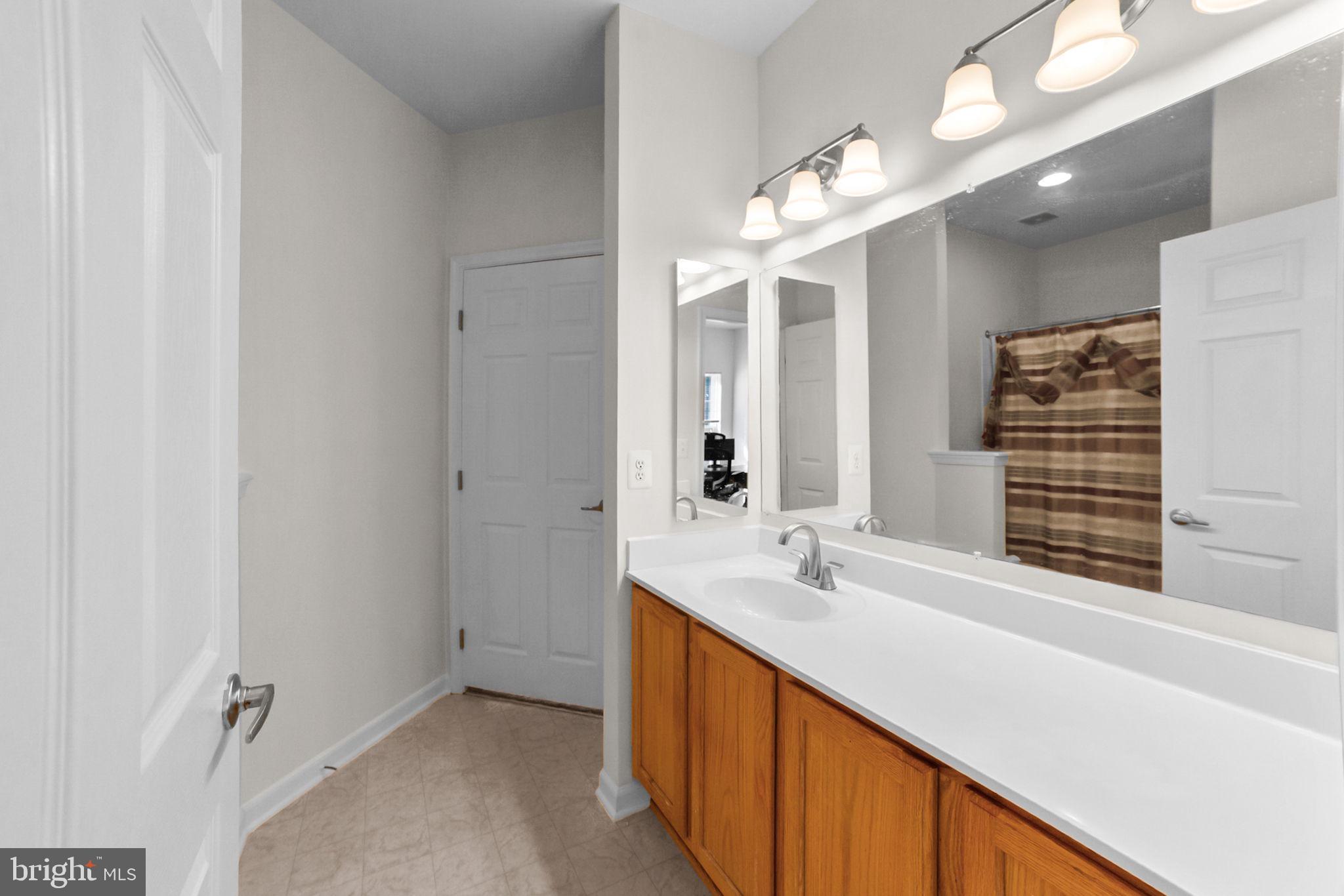 14909 Taryn Lea Court Accokeek, MD 20607 - Photo 27 of 49 a bathroom with a double vanity sink and a mirror