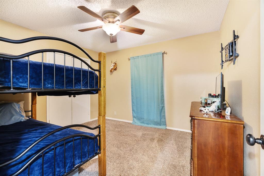 4145 Sleepy Hollow Reno, TX 75462 - Photo 15 of 20 a bed room with a bed and a chandelier