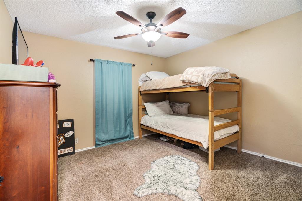 4145 Sleepy Hollow Reno, TX 75462 - Photo 16 of 20 a bedroom with a bed and a chandelier