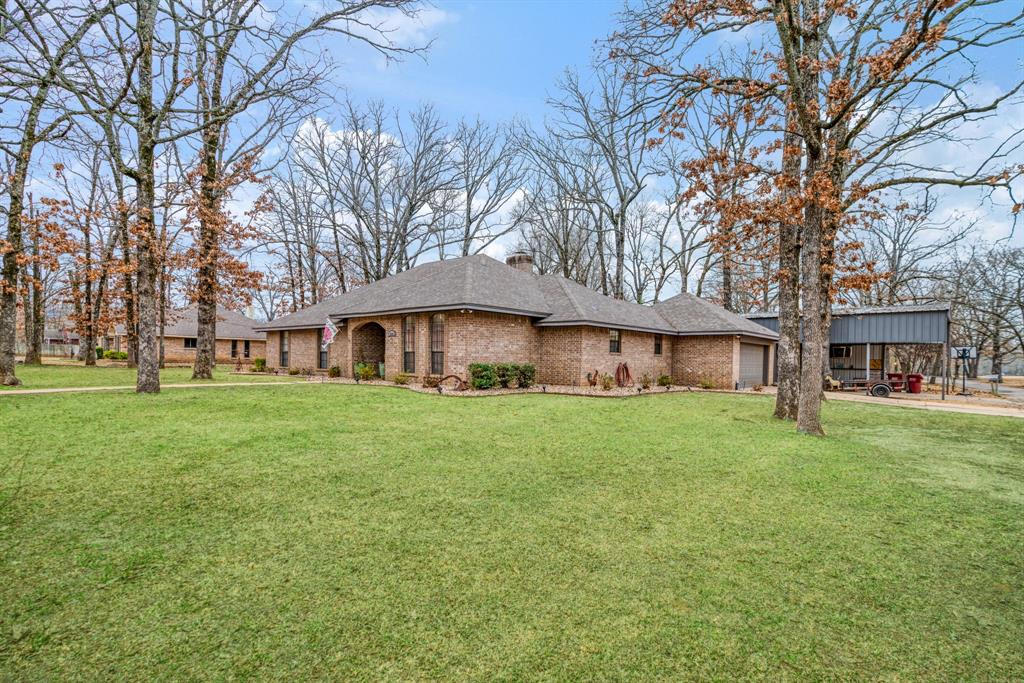 4145 Sleepy Hollow Reno, TX 75462 - Photo 2 of 20 a view of a yard in front of a brick house with a large tree