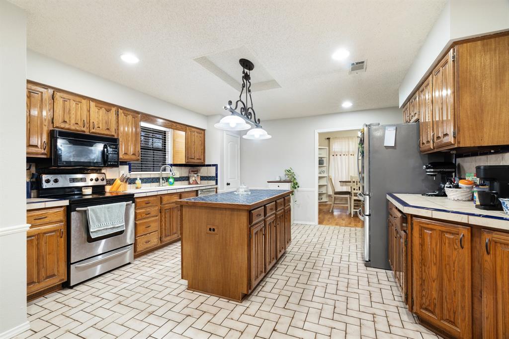 4145 Sleepy Hollow Reno, TX 75462 - Photo 6 of 20 a kitchen with stainless steel appliances granite countertop a sink and cabinets