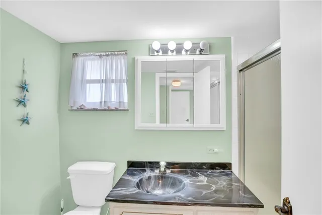 a bathroom with a sink a toilet and mirror