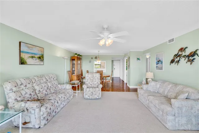 a living room with furniture and kitchen view