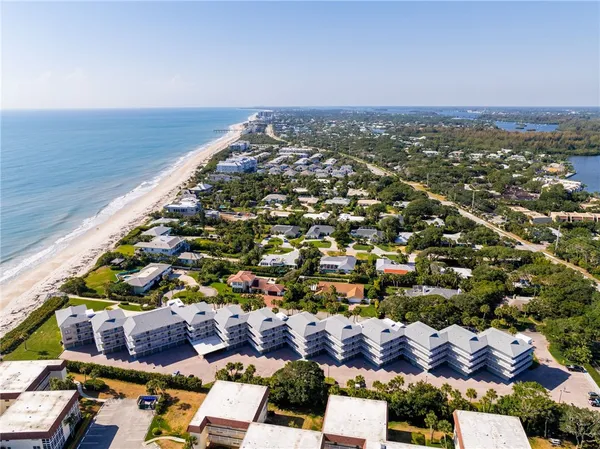 an aerial view of a building with an ocean and mountain view