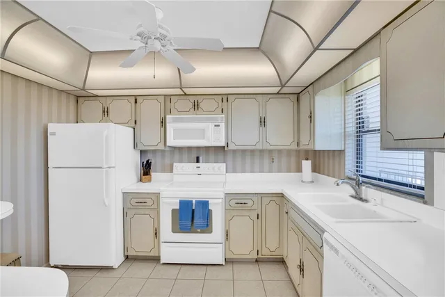 a kitchen with a sink a refrigerator and cabinets