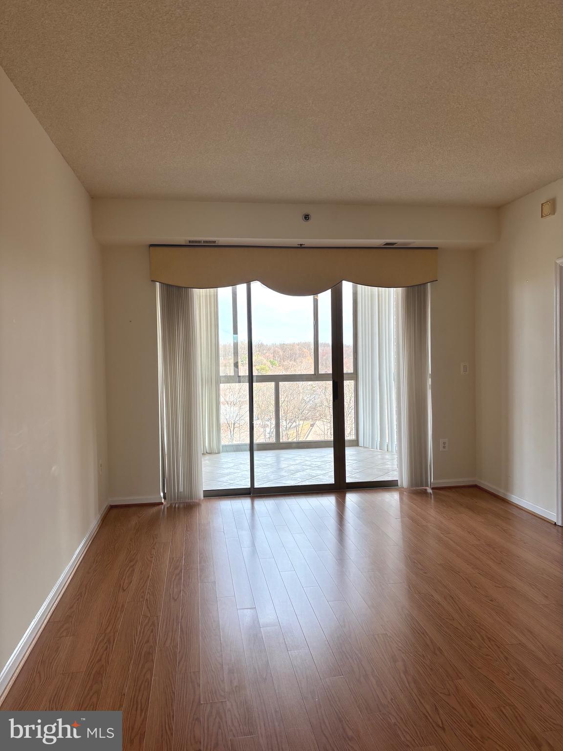 3200 North Leisure World Boulevard, Unit 911 Silver Spring, MD 20906 - Photo 17 of 39 a view of an empty room with wooden floor and a window