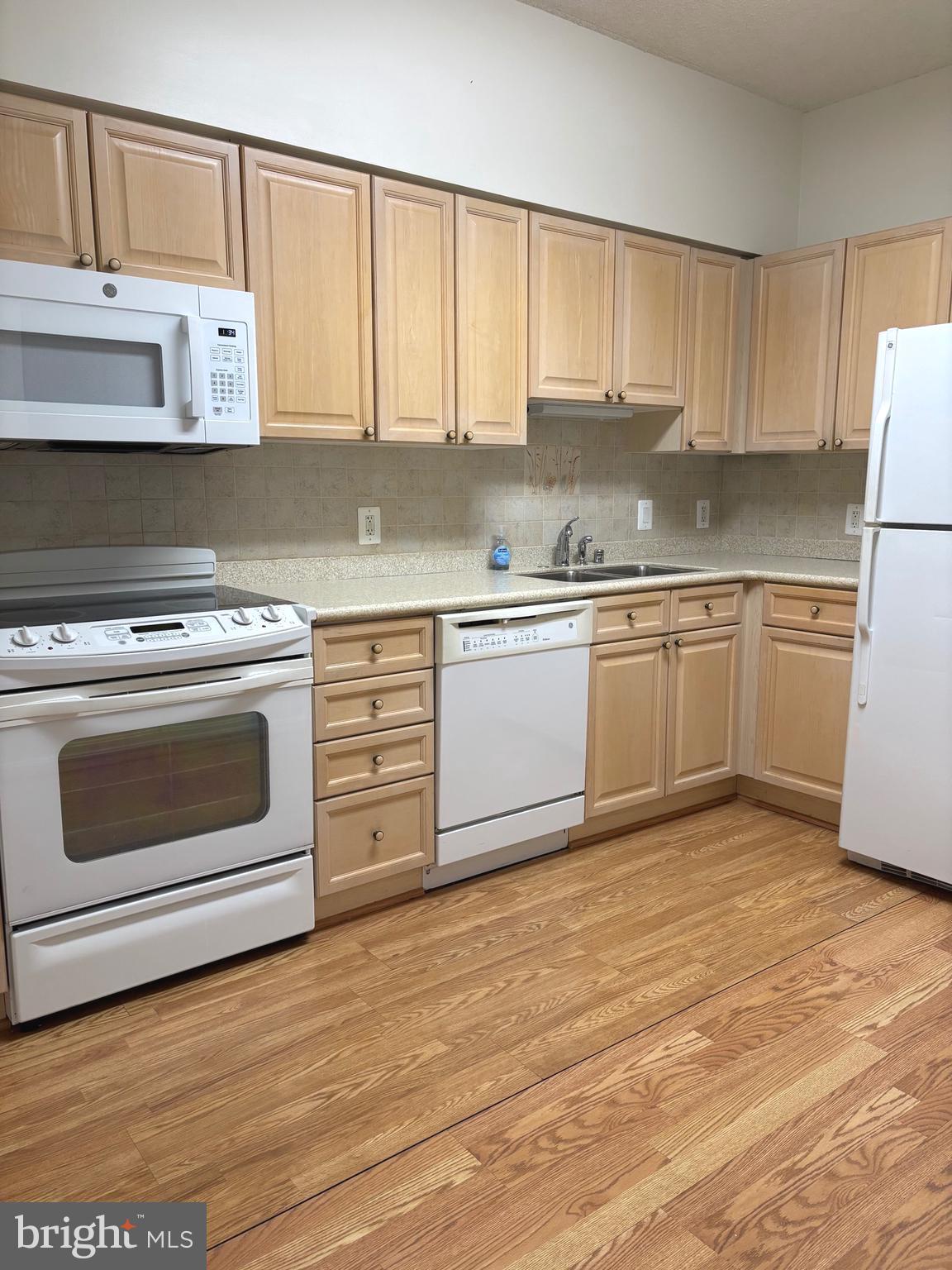 3200 North Leisure World Boulevard, Unit 911 Silver Spring, MD 20906 - Photo 20 of 39 a kitchen with granite countertop white cabinets and white appliances