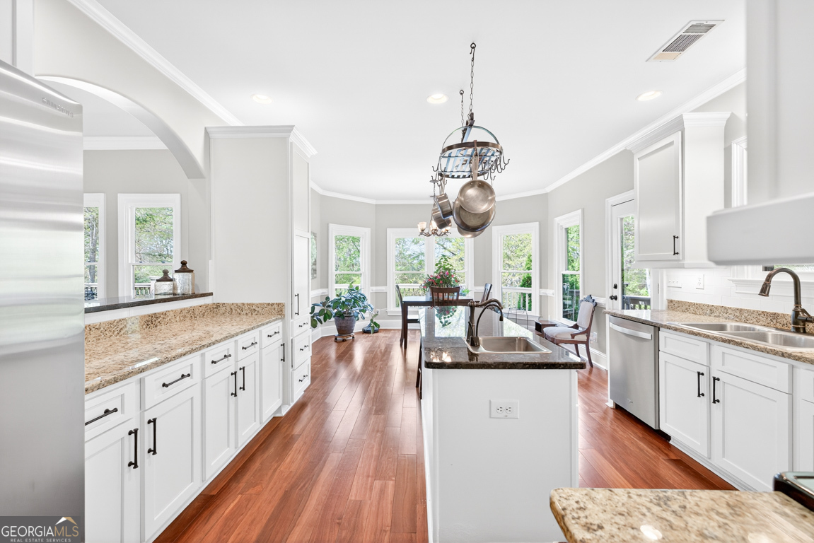1121 Deer Trail Bishop, GA 30621 - Photo 19 of 98 a large kitchen with kitchen island lots of counter space wooden floor and stainless steel appliances