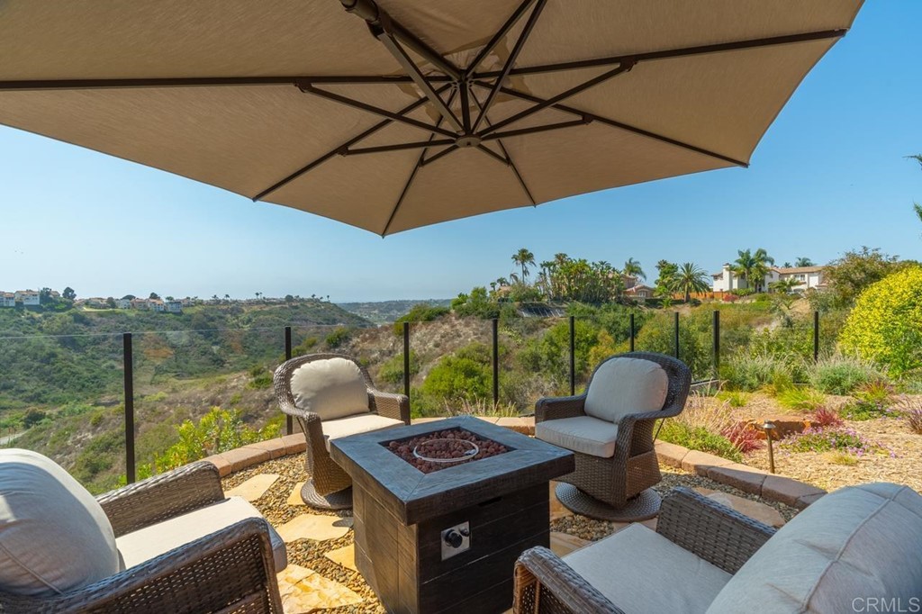 1784 Hawk View Drive Encinitas, CA 92024 - Photo 11 of 71 a view of a balcony with a table and chairs under an umbrella