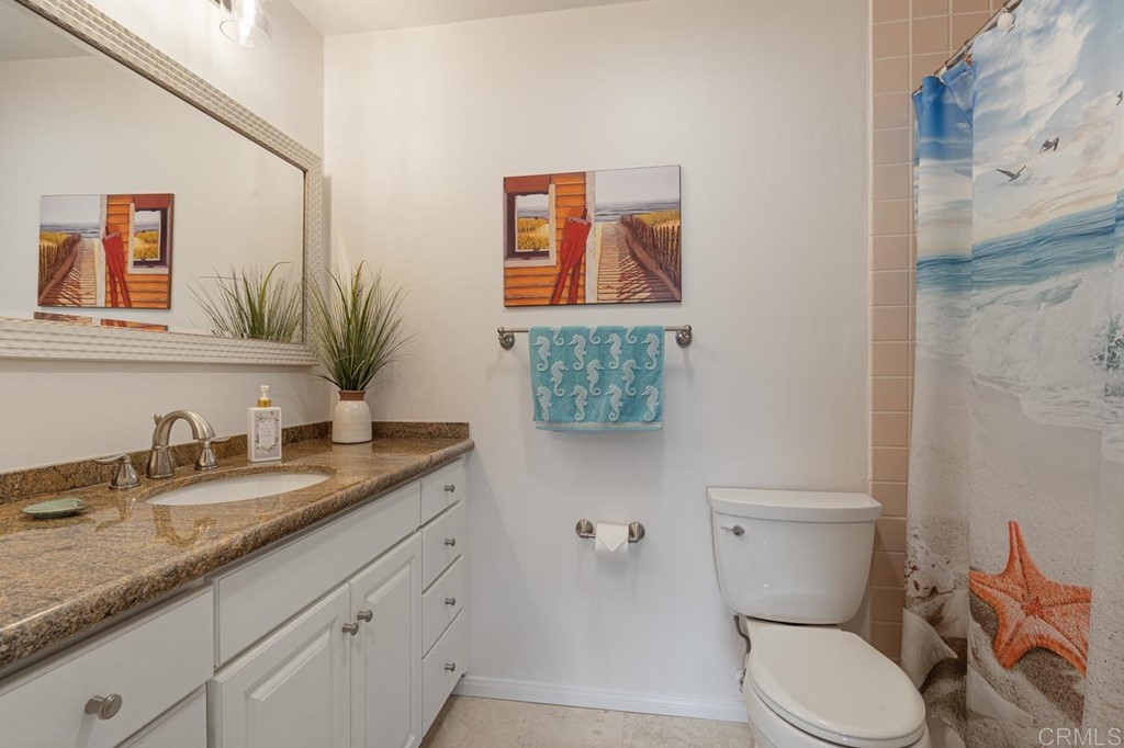 1784 Hawk View Drive Encinitas, CA 92024 - Photo 68 of 71 a bathroom with a granite countertop toilet sink and mirror