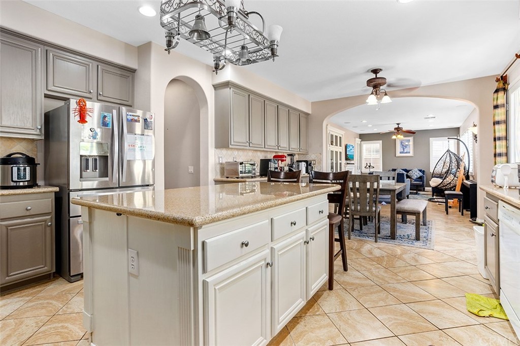 12547 Vintner Drive Rancho Cucamonga, CA 91739 - Photo 22 of 52 a kitchen with stainless steel appliances granite countertop a refrigerator a sink dishwasher a dining table and chairs with wooden floor