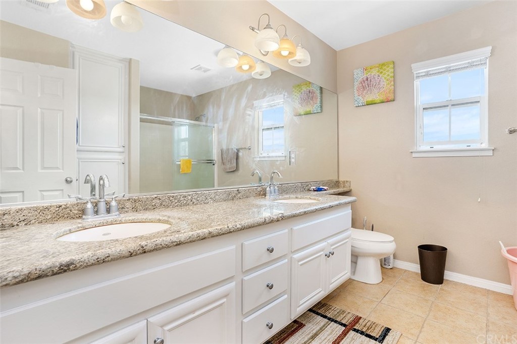 12547 Vintner Drive Rancho Cucamonga, CA 91739 - Photo 36 of 52 a bathroom with a granite countertop sink mirror and toilet