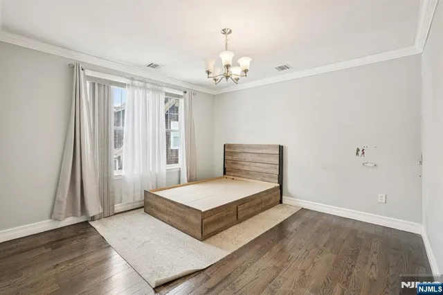 a spacious bedroom with a bed and a chandelier