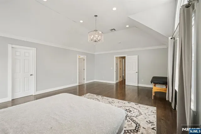 a bedroom with a bed and a lamp on dresser