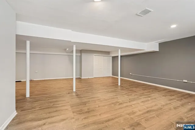an empty room with wooden floor and window