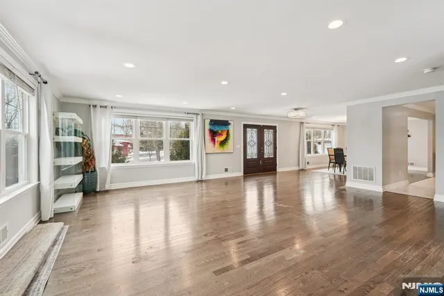 a view of an empty room with window and wooden floor