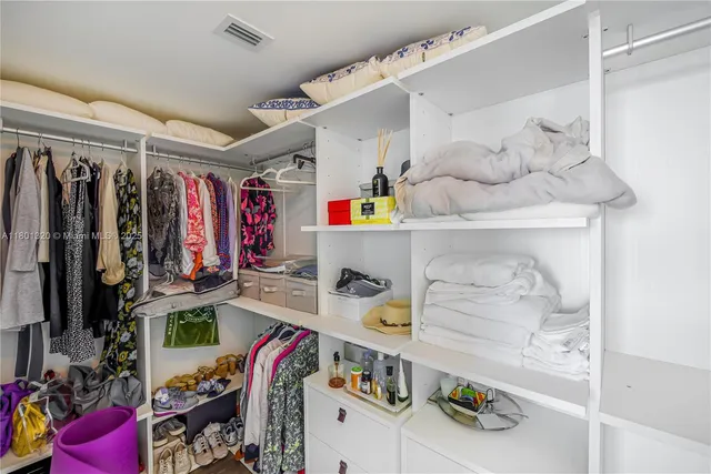 a view of walk in closet with clothes