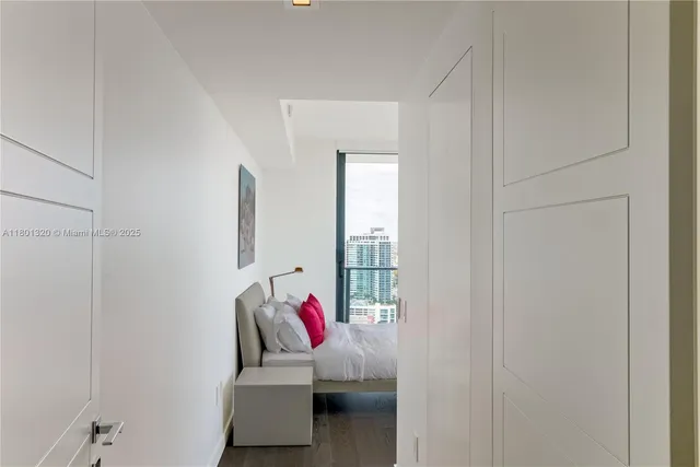 a bedroom with a bed and a large window