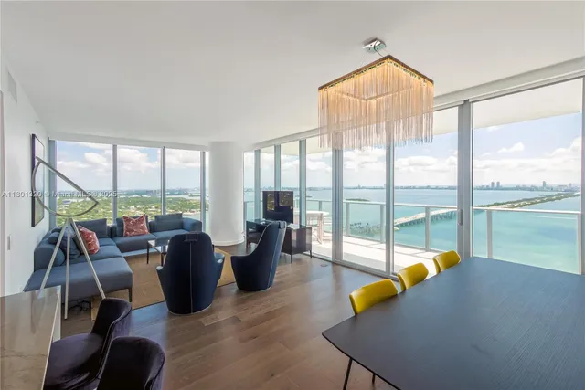 a living room with furniture and floor to ceiling windows