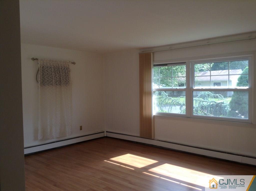 25 Cambridge Road Edison, NJ 08817 - Photo 2 of 13 a view of an empty room with wooden floor and a window