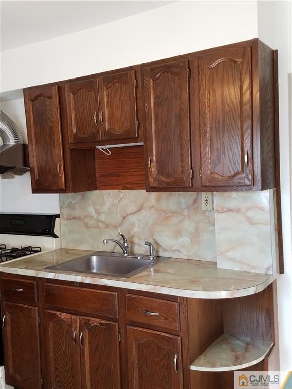 25 Cambridge Road Edison, NJ 08817 - Photo 10 of 13 a kitchen with granite countertop wood cabinets stainless steel appliances and a sink