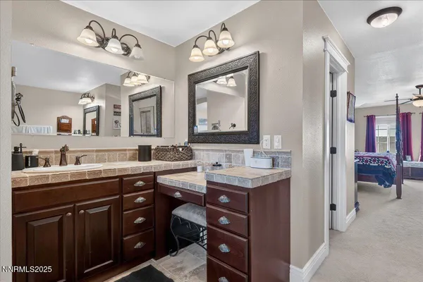 a en suite bathroom with a double vanity sink and a mirror