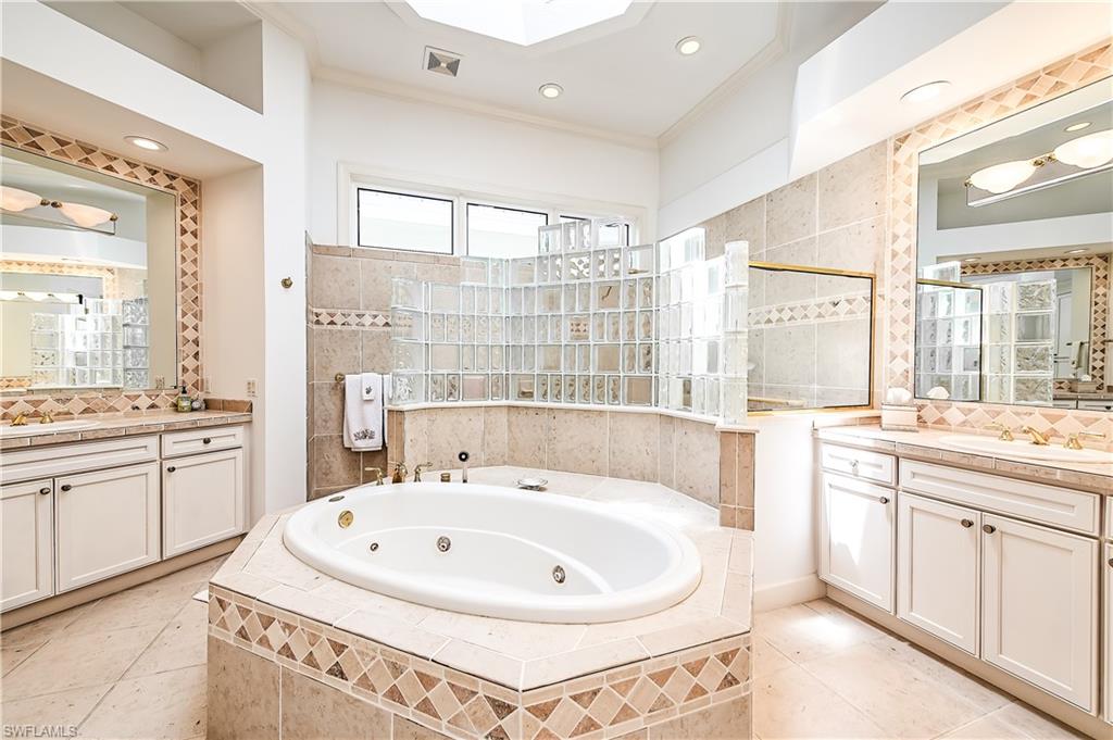 7084 Verde Way Naples, FL 34108 - Photo 16 of 18 a bathroom with a tub sink and mirror
