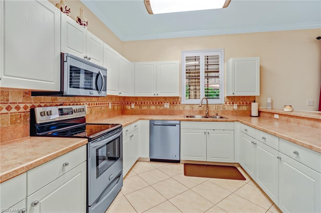 15663 Summit Pl Circle, Unit 328 Naples, FL 34119 - Photo 11 of 32 a kitchen that has a sink and a stove in it