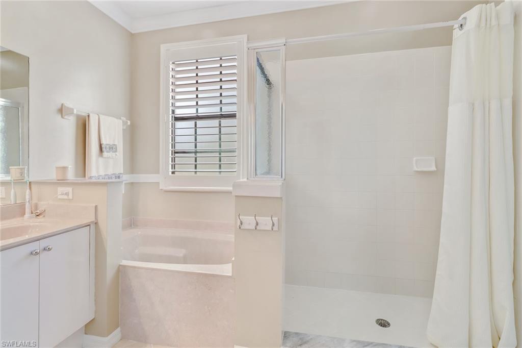 15663 Summit Pl Circle, Unit 328 Naples, FL 34119 - Photo 21 of 32 a bathroom with a bathtub and a shower