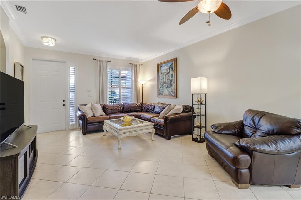 15663 Summit Pl Circle, Unit 328 Naples, FL 34119 - Photo 3 of 32 a living room with furniture and a flat screen tv