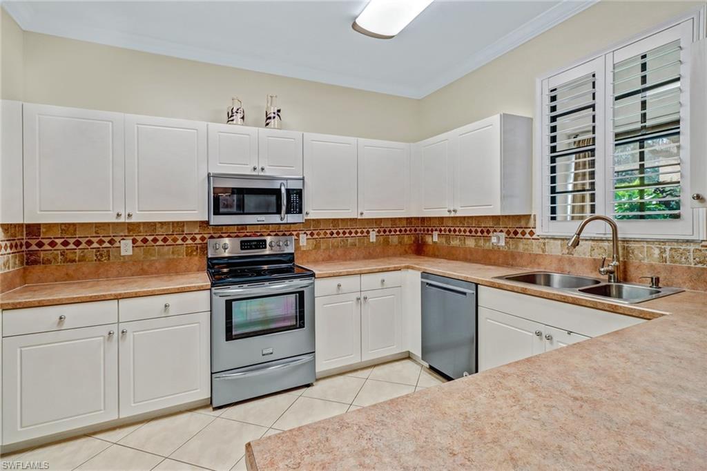 15663 Summit Pl Circle, Unit 328 Naples, FL 34119 - Photo 10 of 32 a kitchen with cabinets appliances a sink and a counter top space