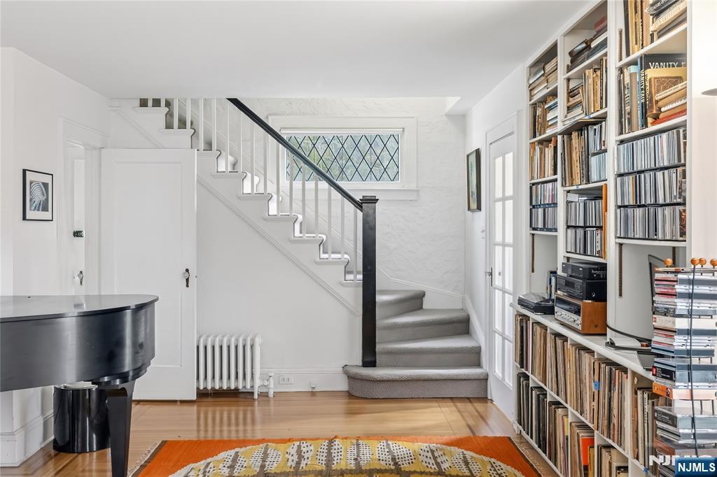 69 Sussex Road Tenafly, NJ 07670 - Photo 11 of 39 a view of staircase with lots of frames on wall and a view of living room