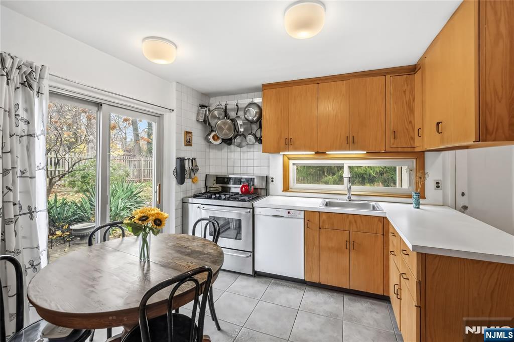 69 Sussex Road Tenafly, NJ 07670 - Photo 19 of 39 a kitchen with a table chairs sink and cabinets
