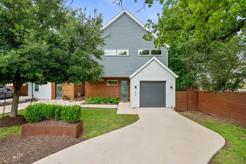 a front view of a house with yard and trees