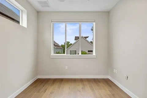 a view of a small space with wooden floor and a window