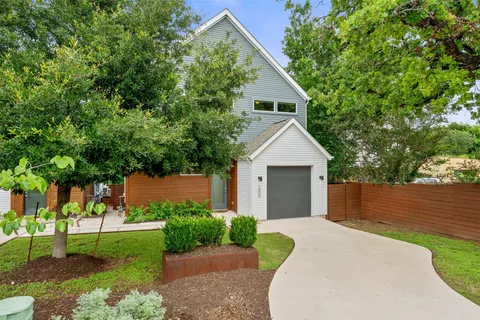 a front view of a house with a yard and trees