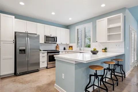 a kitchen with kitchen island a refrigerator stove microwave and cabinets