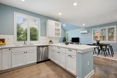 a kitchen that has a sink a stove counter top space and cabinets