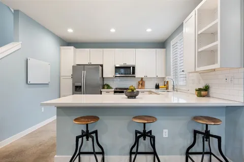 a kitchen with stainless steel appliances a sink and a refrigerator