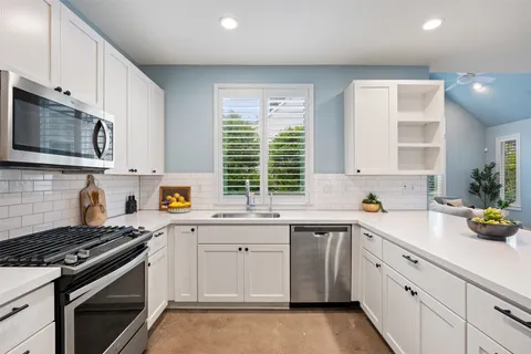 a kitchen with a sink stove and microwave