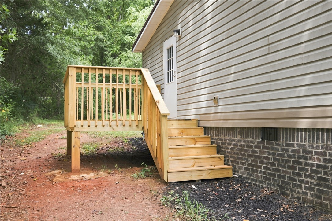 213 Old River Road Pelzer, SC 29669 - Photo 24 of 27 A newly constructed wooden deck and staircase offer convenient access to the elevated side entry.