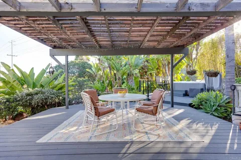 a spacious bedroom with a bed and a lamp on a dresser