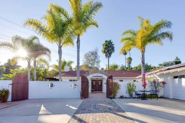 front view of a house with a palm tree