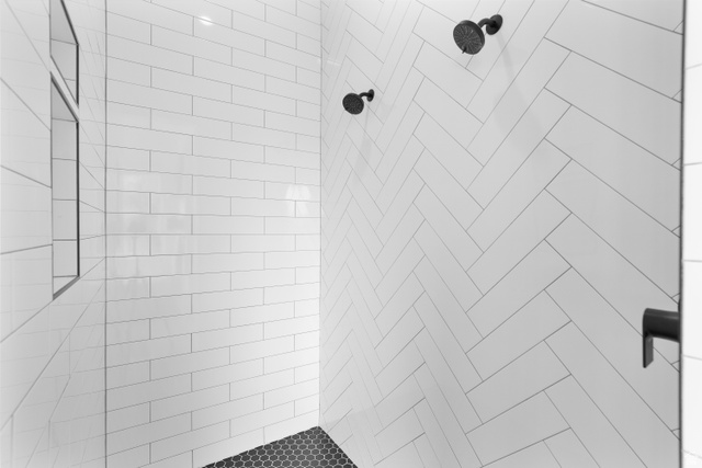 2278 Tawny Ridge Circle St. George, UT 84790 - Photo 29 of 61 Shower with white subway tile in a herringbone pattern, matte black fixtures, and a black hexagonal tile floor.