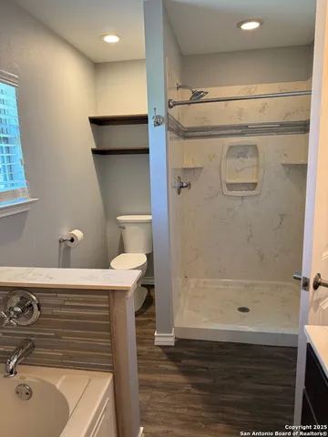 a bathroom with a sink a toilet and shower