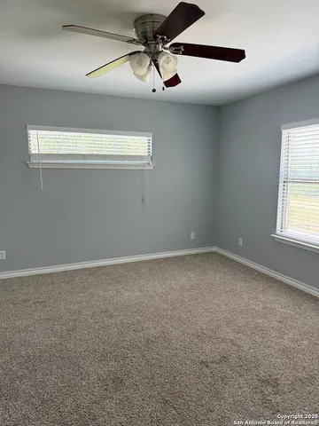 a view of a room with ceiling fan and window