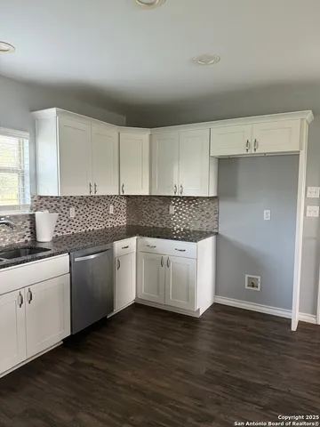 a kitchen with granite countertop white cabinets and white appliances